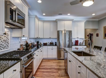 High-end luxury kitchen with granite countertops and white cabinets.